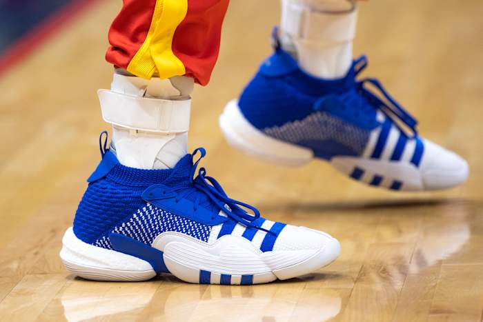 View of Trae Young's blue and white adidas shoes.